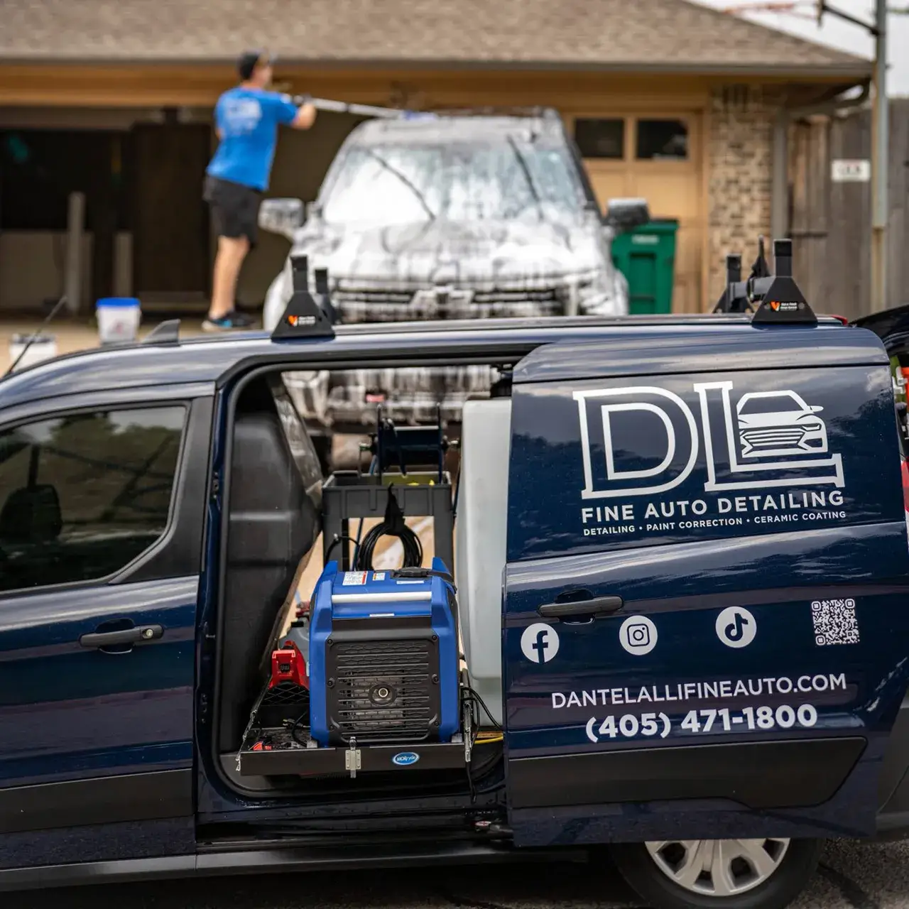 Dante powerwashing vehicle behind DL Fine Auto van