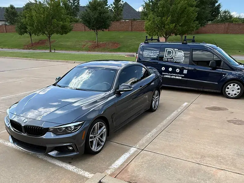 BMW parked next to DL Fine Auto van